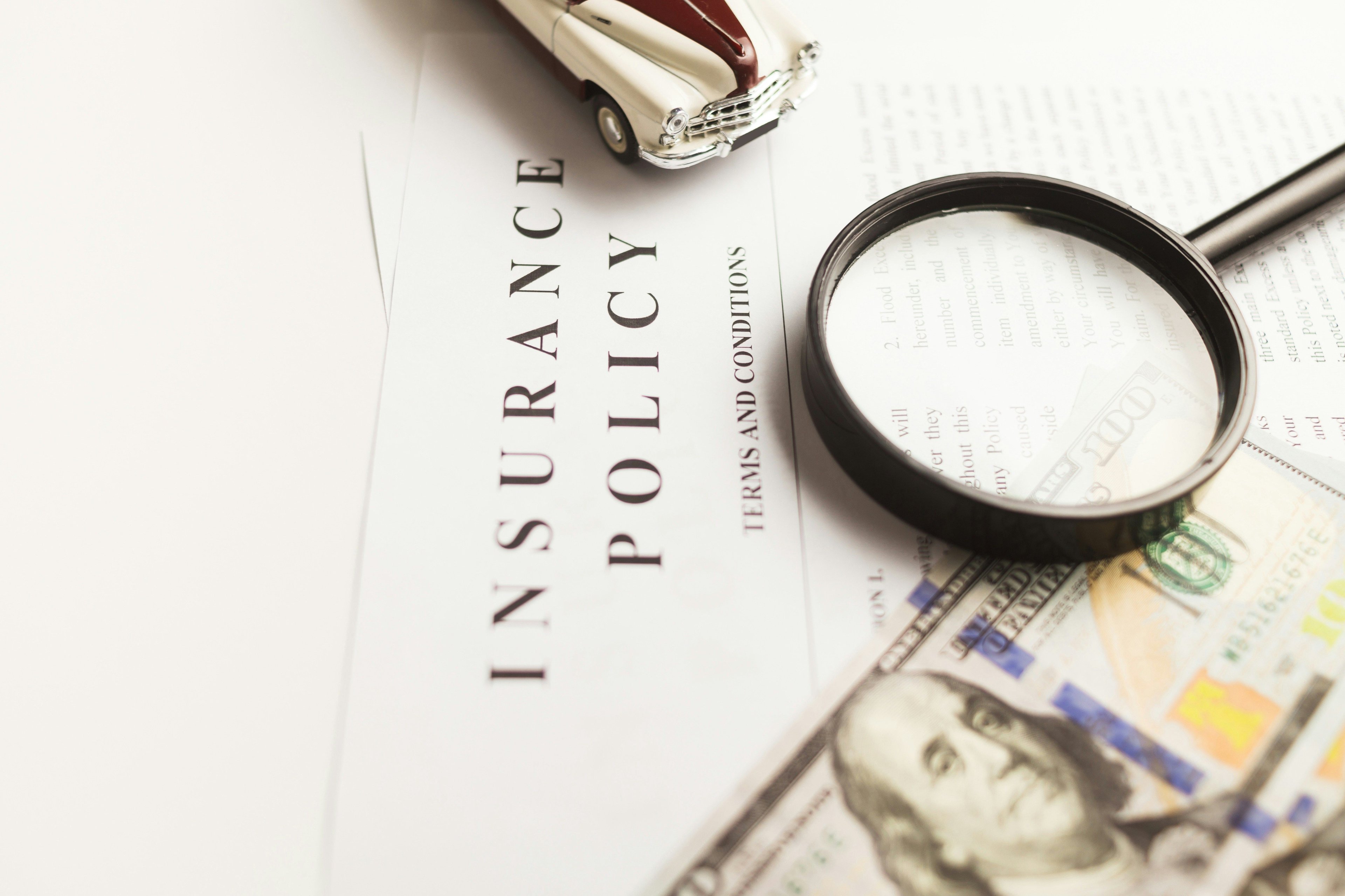 Magnifying glass on top of an insurance policy document